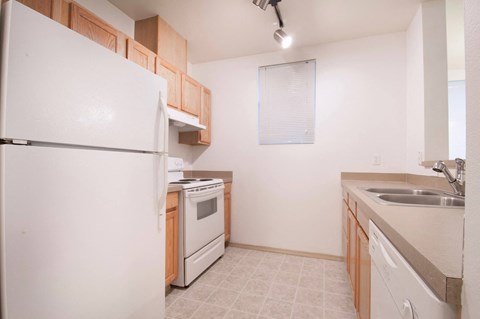 a kitchen with white appliances and wooden cabinets